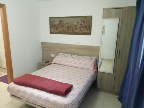 a small bedroom with a bed and a mirror at Alojamientos Playa Centro Corralejo 1 in Corralejo