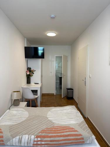 a bedroom with a bed and a desk and a kitchen at Stendaler Apartments in Stendal
