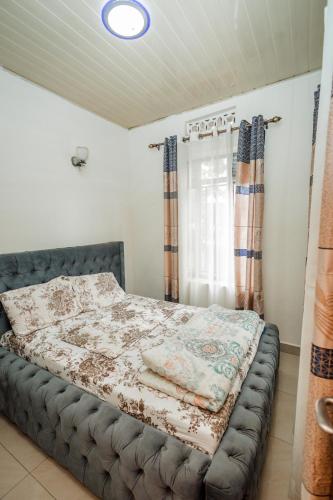 - une chambre avec un lit dans une chambre avec des rideaux dans l'établissement Casa Kigali, à Kigali