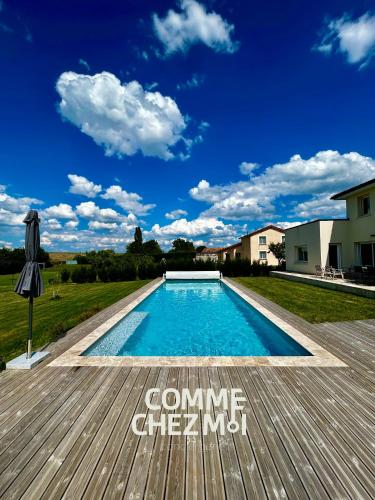 une piscine avec une terrasse en bois à côté d'une maison dans l'établissement Villa avec piscine pour 10 personnes - Lac du Der Giffaumont, à Giffaumont