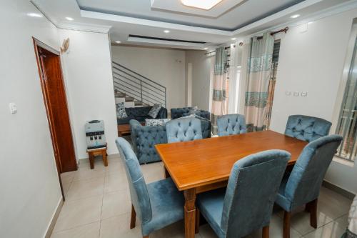 une salle à manger avec une table en bois et des chaises bleues dans l'établissement Casa Kigali, à Kigali