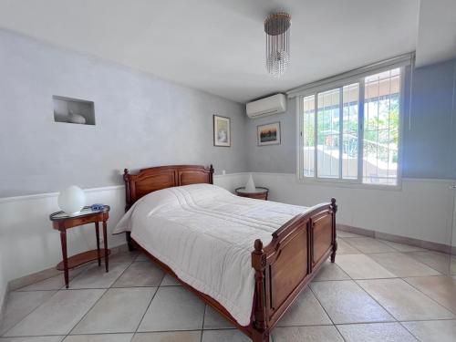 une chambre avec un grand lit et une fenêtre dans l'établissement Maison de villa avec piscine privée à deux pas de centre de Montpellier, à Montpellier