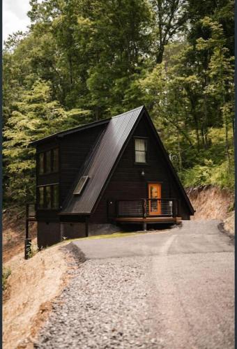 a small black house on a dirt road at My Tennessee A-Frame by Avada Properties in Sevierville