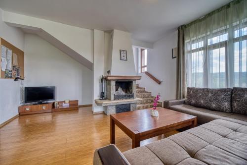 a living room with a couch and a fireplace at Guest House Ivanini Houses in Tryavna
