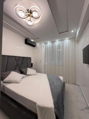 a bedroom with a large bed with a ceiling fan at Jardins Anass 2 Aéroport Marrakech in Marrakech