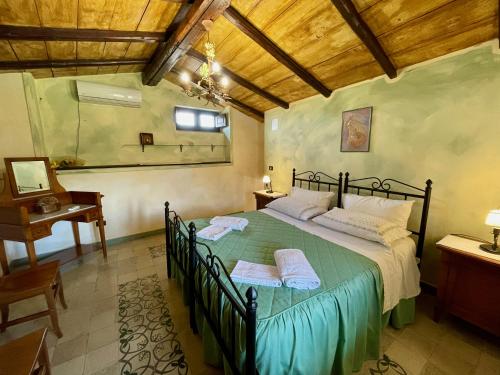 a bedroom with a large bed in a room with a desk at Le Querce di Cota in Troina