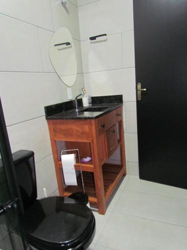 un bagno con lavandino, WC e specchio di Cabanas LUPE Pedro a Governador Celso Ramos