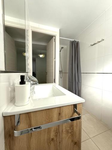 a bathroom with a white sink and a mirror at La Casa AZUL in Ardales