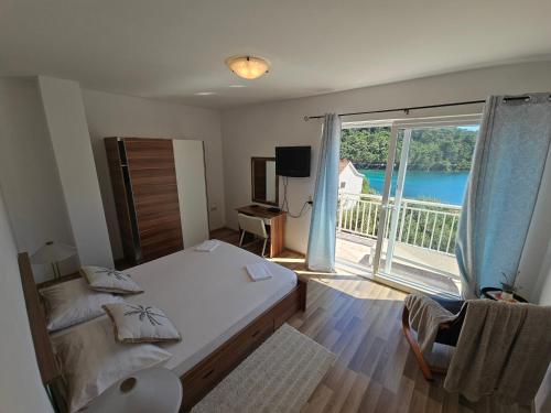 a bedroom with a bed and a large window at Apartments Angela in Goveđari