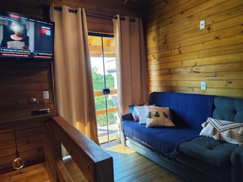 un soggiorno con un divano blu e una televisione di Cabanas LUPE Pedro a Governador Celso Ramos