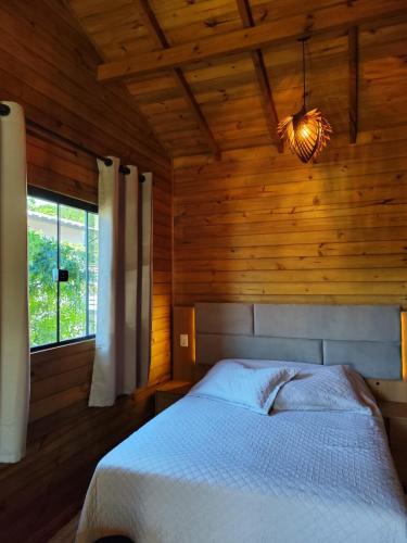 a bedroom with a bed in a wooden room at Cabanas LUPE Pedro in Governador Celso Ramos