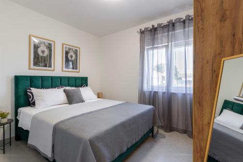 a bedroom with a large bed and a window at Apartmani Sofija in Bibinje