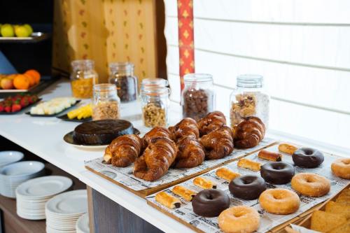 ein Tisch mit vielen verschiedenen Donuts und anderen Lebensmitteln in der Unterkunft Hotel Rey Arturo Burgos in Villagonzalo-Pedernales