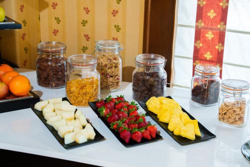 Una mesa cubierta con platos de comida y frascos de frutos secos y frutas. en Hotel Rey Arturo Burgos, en Villagonzalo Pedernales