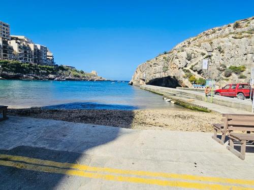 a bench sitting next to a body of water at Seaside apartment in the heart of Xlendi Gozo in Xlendi