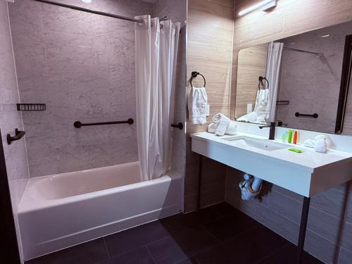 ein Badezimmer mit Badewanne, Waschbecken und Dusche in der Unterkunft Bkway Hotel Brooklyn in Brooklyn