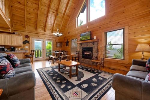 a living room with a fireplace in a log cabin at Mountain Sunrise by Avada Properties in Sevierville