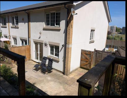 ein weißes Haus mit einem Zaun und einer Terrasse in der Unterkunft Enbrook Valley House - 3 Bedrooms Folkestone in Folkestone