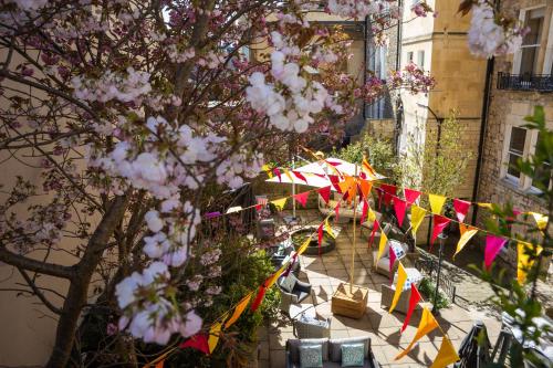 a street with flags and tables and a tree at Dukes Bath in Bath