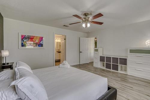 a white bedroom with a bed and a ceiling fan at Family-Friendly 3BR w Private Pool & BBQ in SW Austin in Bee Cave