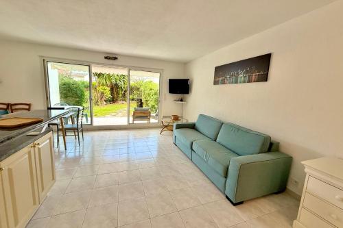 un salon avec un canapé bleu et une table dans l'établissement Golfe-Juan 4 People Garden & Garage, au Golfe-Juan