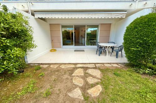 un patio avec une table et des chaises devant une maison dans l'établissement Golfe-Juan 4 People Garden & Garage, au Golfe-Juan
