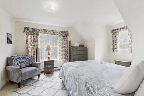 a bedroom with a bed and a chair and windows at Island Pines in Southport