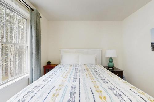 a bed in a white room with a window at Island Pines in Southport
