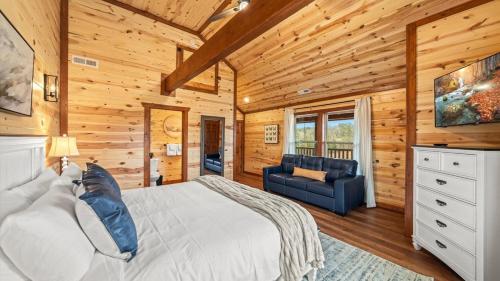 a bedroom with a bed and a couch in a cabin at Jericho Way- luxe retreat indoor pool theater room in Sevierville
