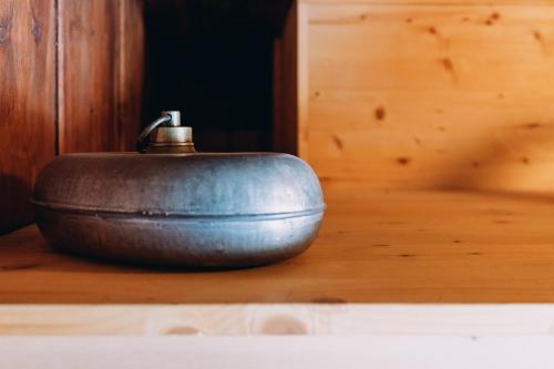 a metal pot sitting on top of a wooden table at Ferienhaus Lindeli, Luxeriös eifach in Sankt Peterzell