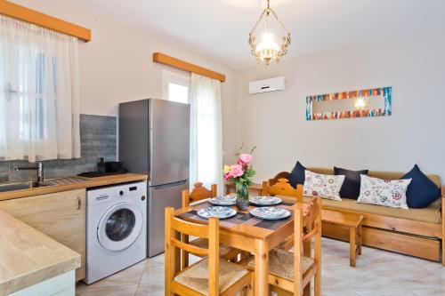 a kitchen and dining room with a table and a refrigerator at Pleiades Apartments in Lefkos Karpathou