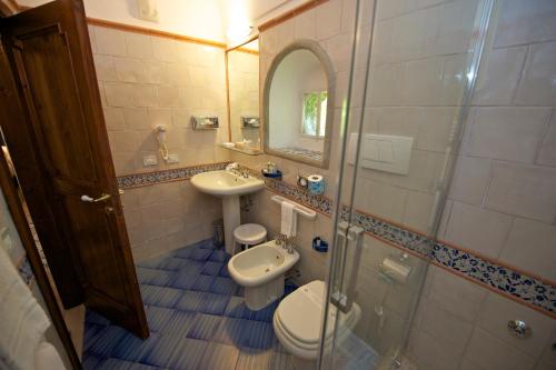 a bathroom with a toilet and a sink and a mirror at Hotel Villa Cimbrone in Ravello