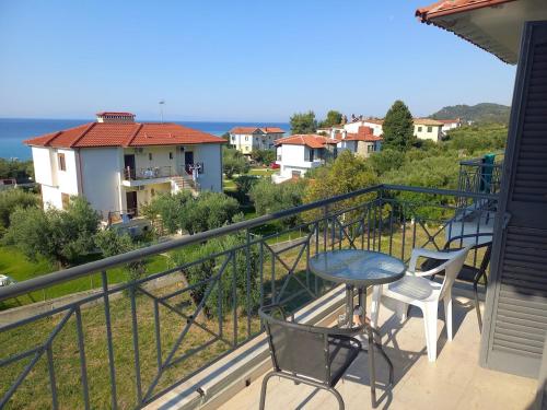 a balcony with a table and chairs and a view at Theros Apartments in Mola Kalyva