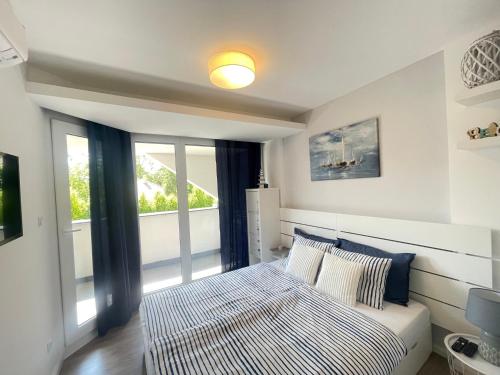 une chambre avec un lit et une grande fenêtre dans l'établissement Lake and Pool Apartman Balatonszemes, à Balatonszemes