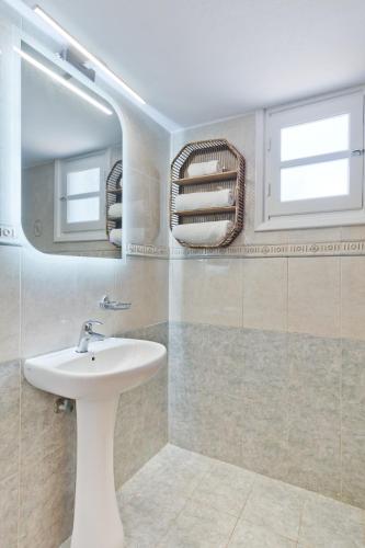 a bathroom with a sink and a mirror at Pleiades Apartments in Lefkos Karpathou