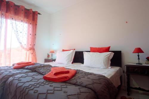 a bedroom with a bed with red towels on it at Ria Formosa Pineview in Faro