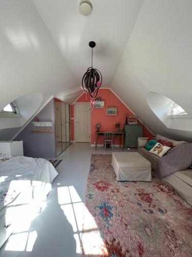 a attic room with a bed and a couch at 5 bedroom Spectacular view & charming house in Vollen centre in Vollen