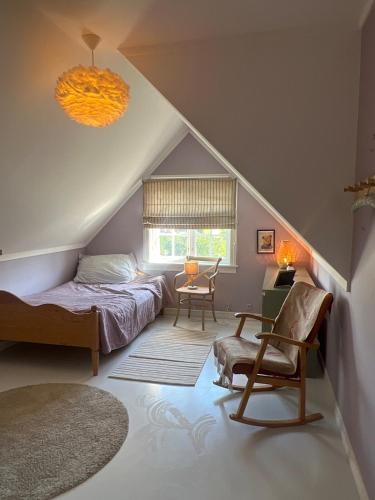 a attic bedroom with a bed and a chair at 5 bedroom Spectacular view & charming house in Vollen centre in Vollen