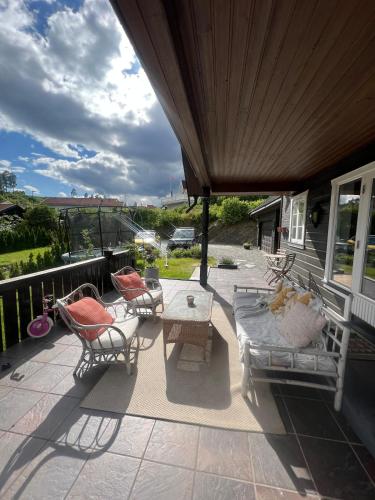 a patio with chairs and a table on a porch at 5 bedroom Spectacular view & charming house in Vollen centre in Vollen