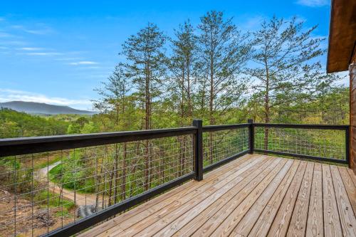 a wooden deck with a view of the woods at Mountain Bliss by Avada Properties in Sevierville
