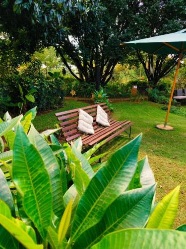 a park bench with two pillows sitting in a park at Windsong Living The Nest in Krugersdorp