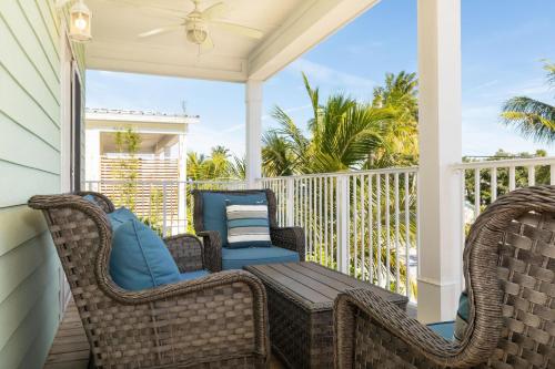 a porch with wicker chairs and a wooden table at #1beautiful 4 Bed 3 Bath Pool Home W Free Dock in Marathon