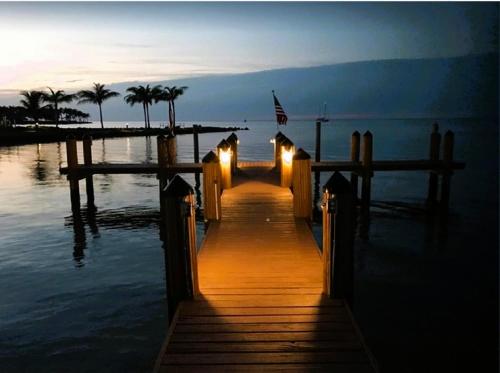 a dock with lights on the water at night at #1beautiful 4 Bed 3 Bath Pool Home W Free Dock in Marathon