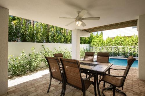 a patio with a table with chairs and a ceiling fan at #1beautiful 4 Bed 3 Bath Pool Home W Free Dock in Marathon