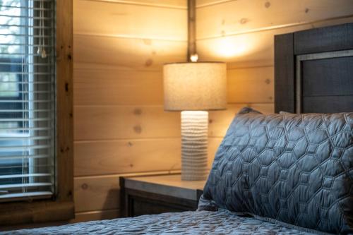 a bedroom with a bed and a lamp on a table at Mountain Bliss by Avada Properties in Sevierville