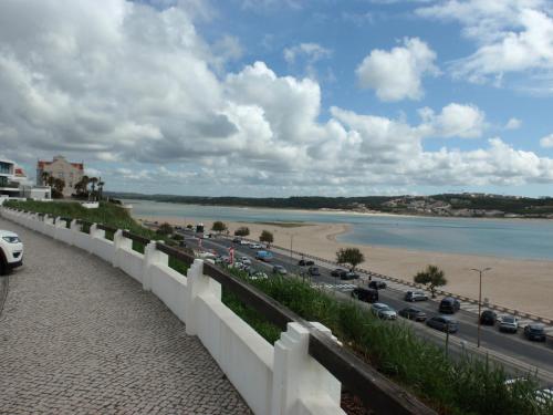 a view of a road and a beach with cars at Foz do Arelho dans un cadre paradisiaque in Foz do Arelho
