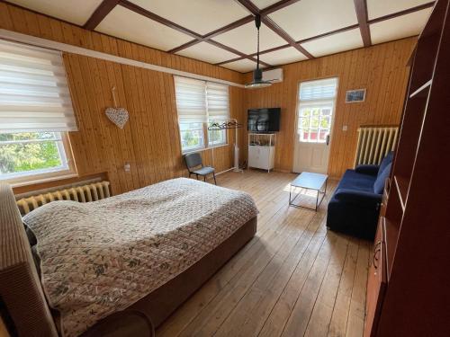 a bedroom with a bed and a blue couch at Villa Rekin in Gdańsk