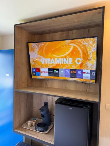 une télévision sur une étagère avec un jeu vidéo dans l'établissement Hotel Capricorne, à Vendôme