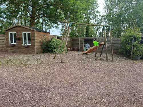 a playground with a slide and a swing at Les épines in Quend-Plage
