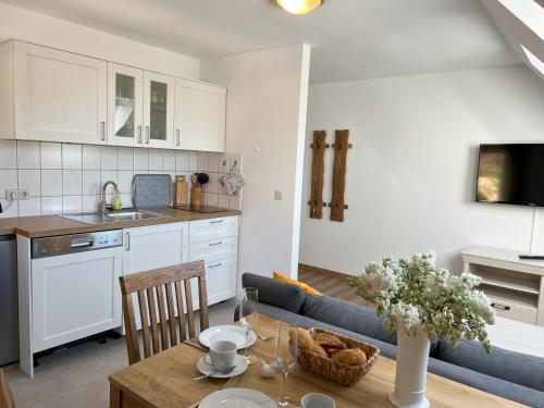 a kitchen and living room with a table and a couch at Strand4-Quartier Ferienwohnungen Ostseebad Karlshagen in Ostseebad Karlshagen